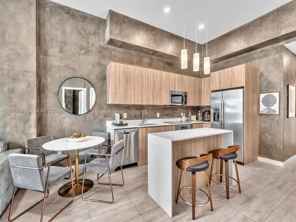 a kitchen with sink a counter and chairs