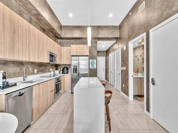 a kitchen with stainless steel appliances granite countertop a sink stove and microwave