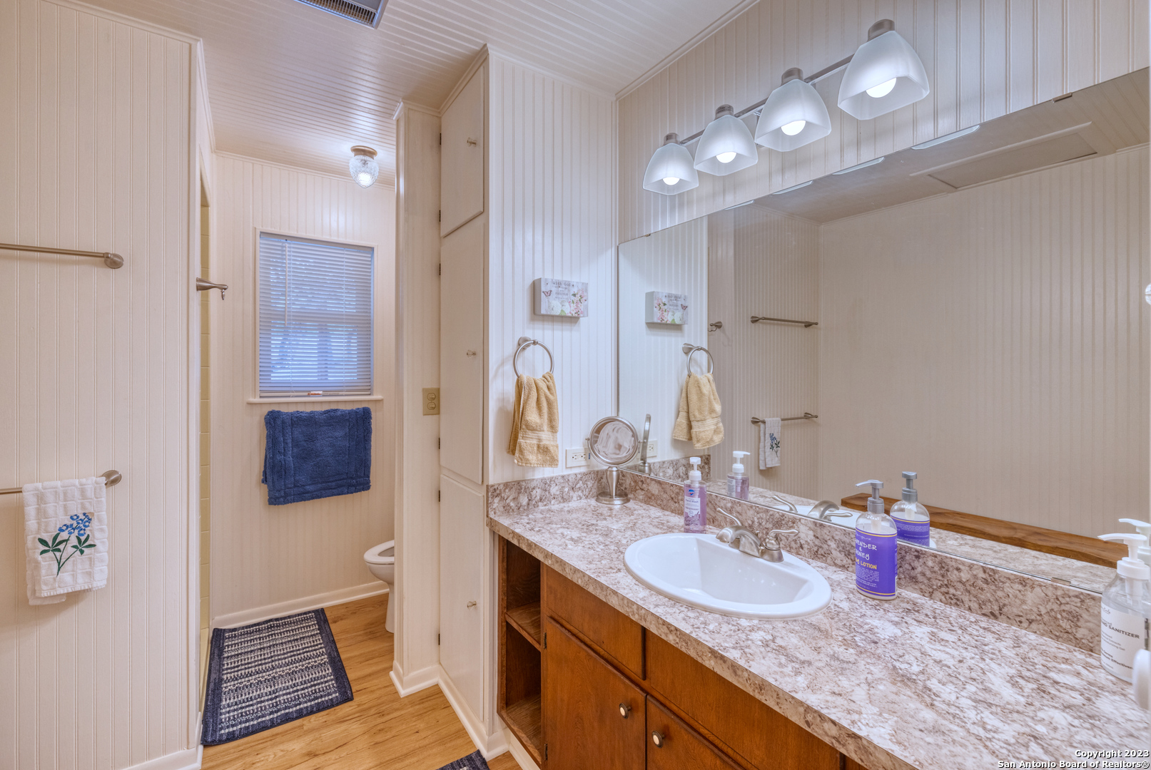 1482 Flatrock Circle Rio Frio, TX 78879 - Photo 20 of 34 a bathroom with a granite countertop sink a toilet a mirror and vanity