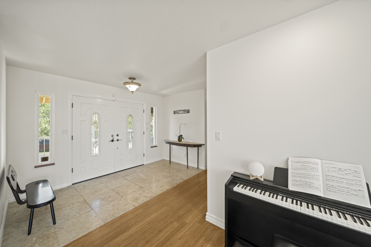 111 Alawaena Street Hilo, HI 96720 - Photo 2 of 28 a view of an empty room with wooden floor and a piano