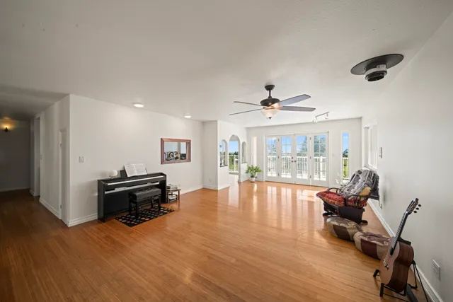 a view of a livingroom with furniture a ceiling fan and wooden floor