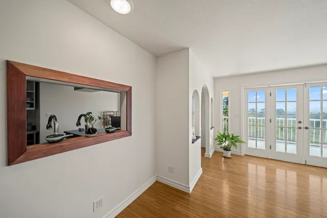 a view of a room with wooden floor and a potted plant