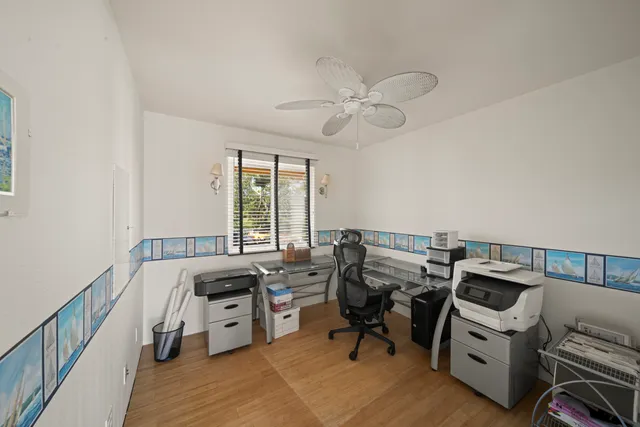 a view of a workspace with furniture and a window