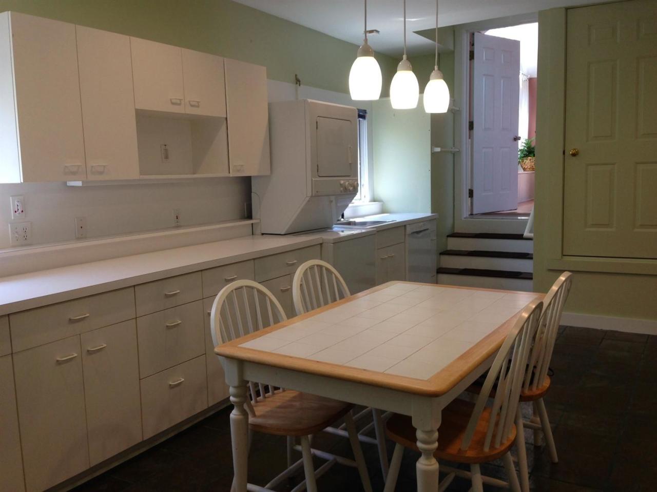 25 Bay View Road Truro, MA 02666 - Photo 20 of 21 a kitchen with a table chairs and a wooden floor