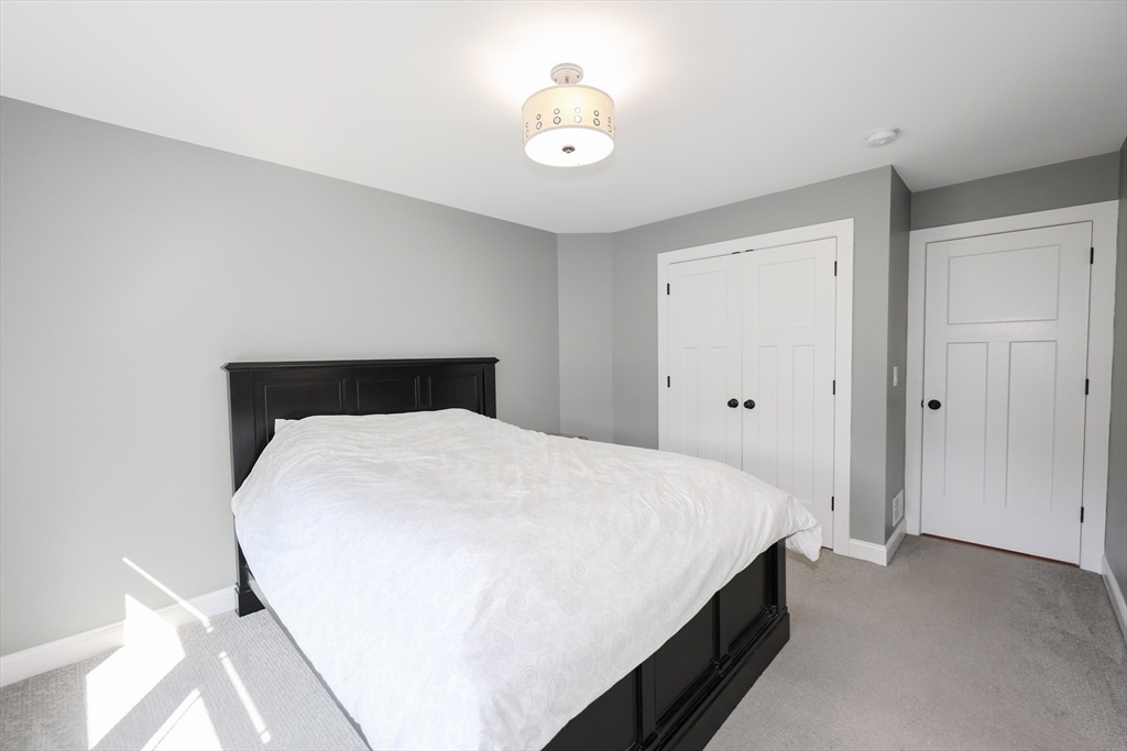 327 North Amherst Road Bedford, NH 03110 - Photo 29 of 39 a bedroom with a bed and a chandelier