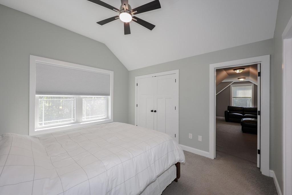 327 North Amherst Road Bedford, NH 03110 - Photo 32 of 39 a bedroom with a bed and a chandelier