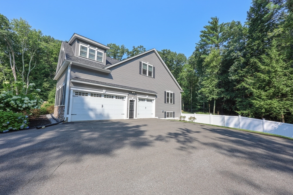 327 North Amherst Road Bedford, NH 03110 - Photo 4 of 39 a front view of a house with a yard and garage