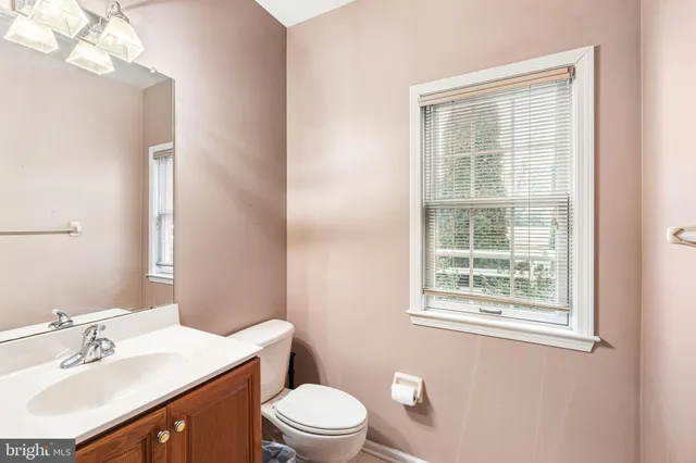 a bathroom with a sink a toilet and a window