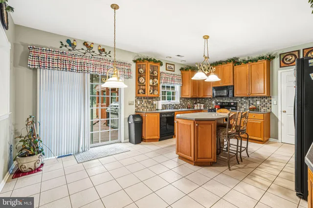 a kitchen with stainless steel appliances kitchen island granite countertop a stove a sink and a refrigerator