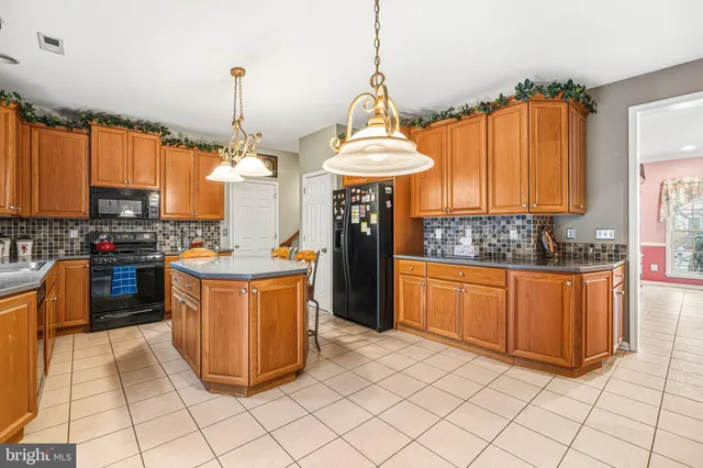 a kitchen with stainless steel appliances granite countertop a stove a sink dishwasher and a refrigerator