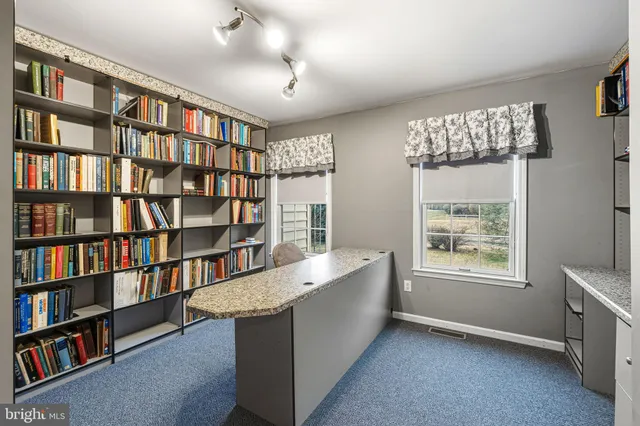 a view of room with windows book shelves