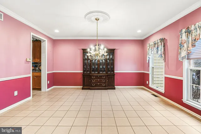 a view of a livingroom with a chandelier fan and windows