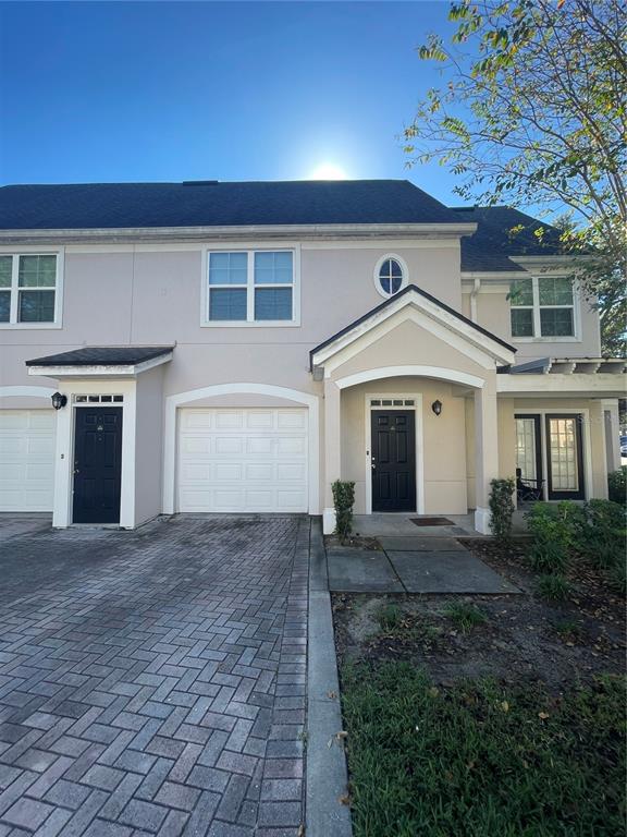 3403 Greenwich Village Boulevard, Unit 203 Orlando, FL 32835 - Photo 1 of 16 a front view of a house with a yard and garage