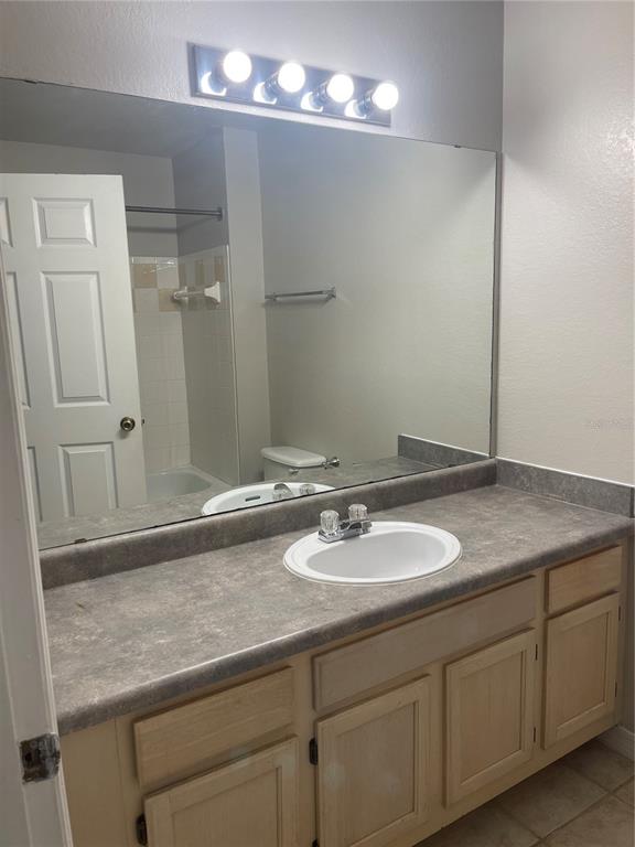 3403 Greenwich Village Boulevard, Unit 203 Orlando, FL 32835 - Photo 8 of 16 a bathroom with a granite countertop sink and a mirror