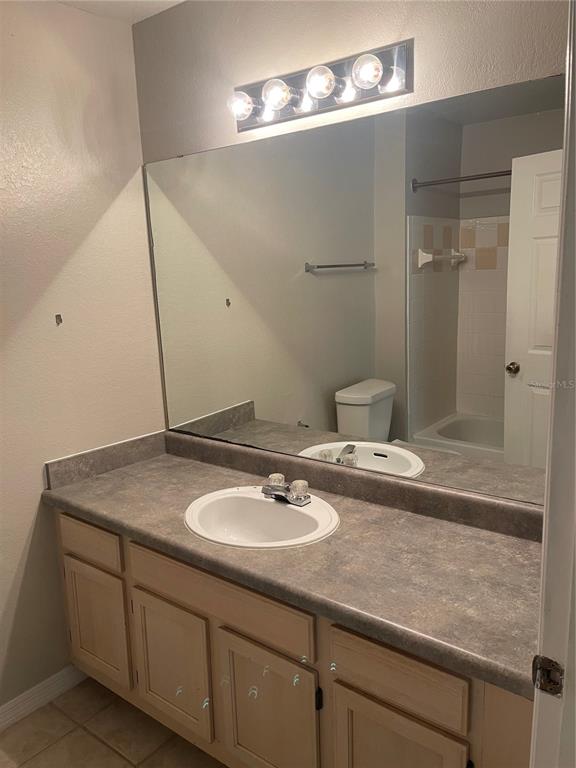 3403 Greenwich Village Boulevard, Unit 203 Orlando, FL 32835 - Photo 10 of 16 a bathroom with a sink vanity granite and shower