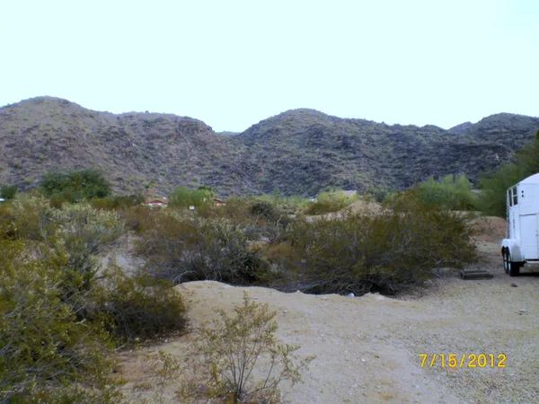 a view of a dry field with mountains in the background