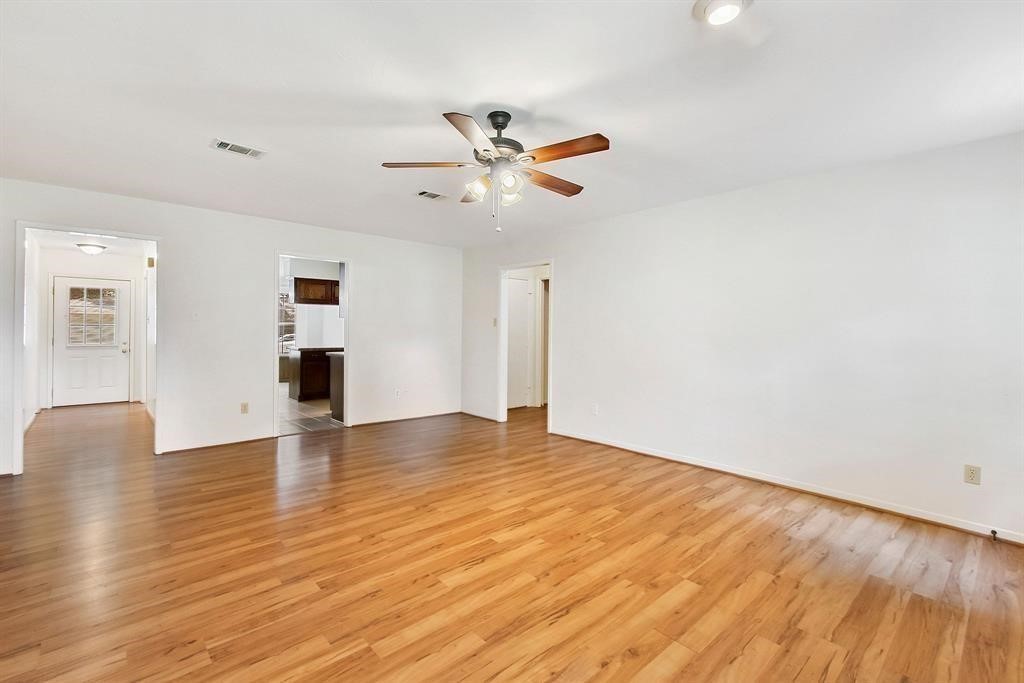 2106 Wickburn Drive Spring, TX 77386 - Photo 14 of 18 a view of an empty room with wooden floor and a ceiling fan