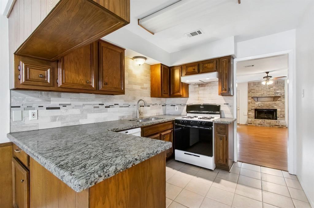 2106 Wickburn Drive Spring, TX 77386 - Photo 17 of 18 a kitchen with stainless steel appliances granite countertop a stove a sink and a microwave