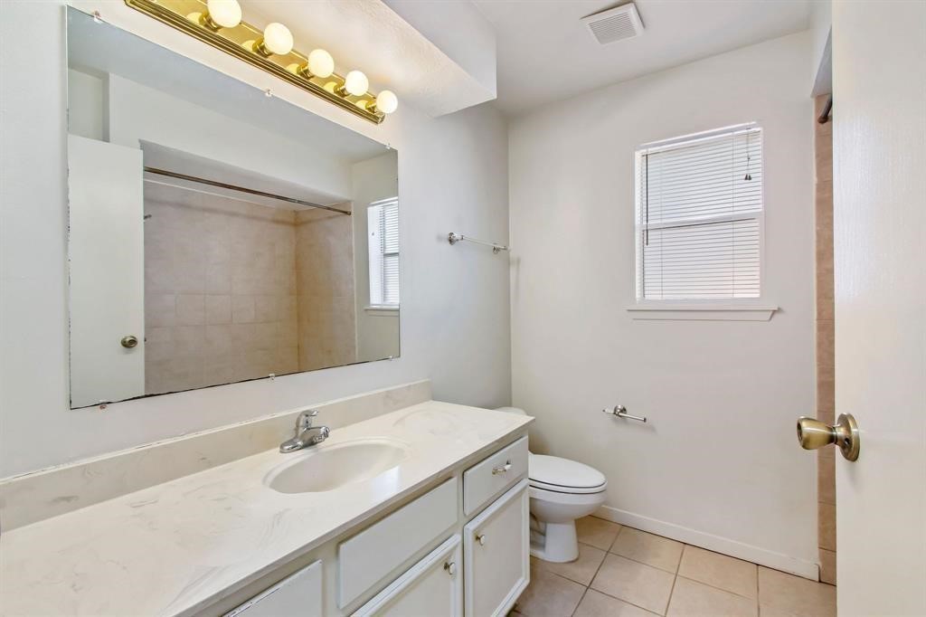 2106 Wickburn Drive Spring, TX 77386 - Photo 10 of 18 a bathroom with a granite countertop toilet a sink and a mirror
