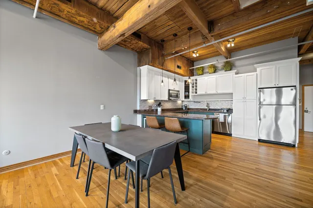 a kitchen with a table chairs and wooden floor