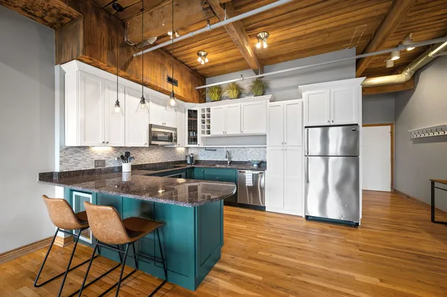 a kitchen with stainless steel appliances granite countertop a sink refrigerator and cabinets