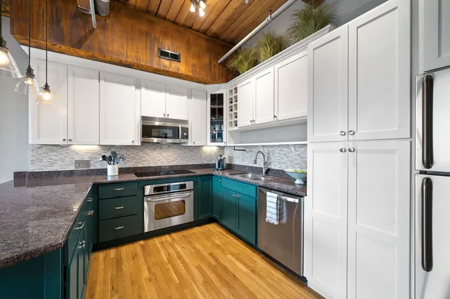 a kitchen with stainless steel appliances granite countertop a stove a sink and a refrigerator
