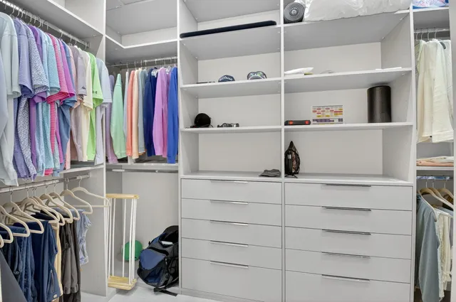 a view of walk in closet with clothes and shoes