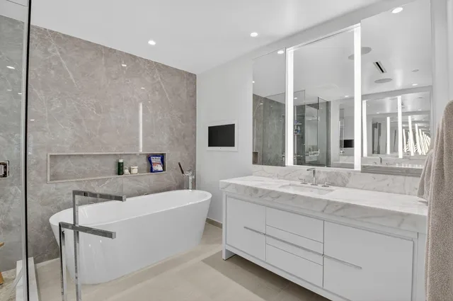 a bathroom with a sink double vanity mirror and bathtub