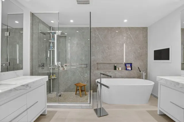 a bathroom with a tub sink a mirror and a shower