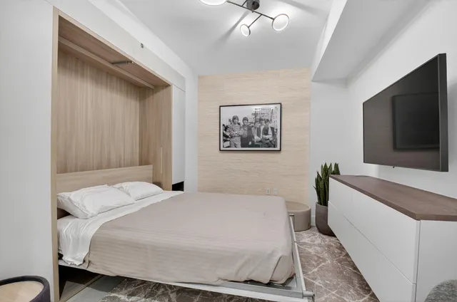 a bedroom with a bed and a flat screen tv