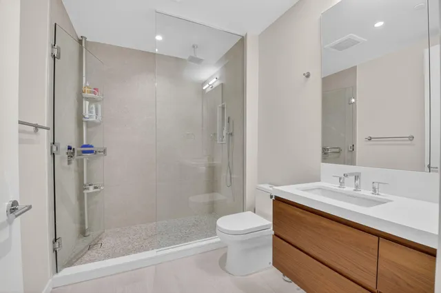 a bathroom with a sink a toilet and shower