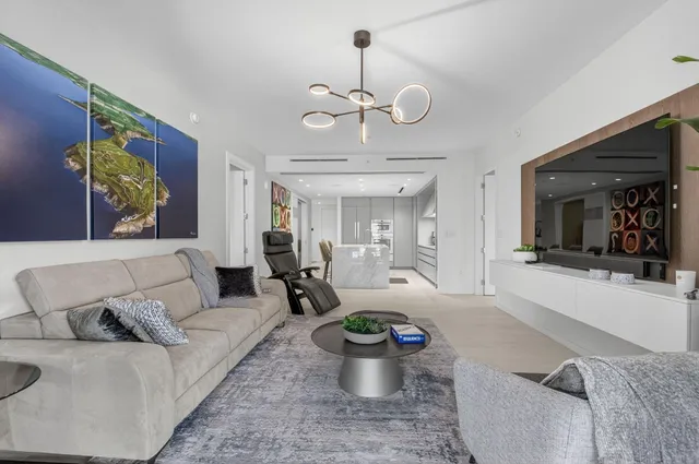 a living room with furniture a chandelier and a fireplace