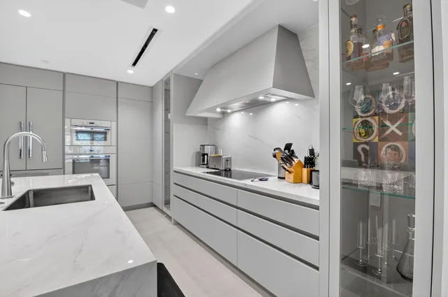 a view of a kitchen with kitchen island a counter top space a sink stainless steel appliances and cabinets