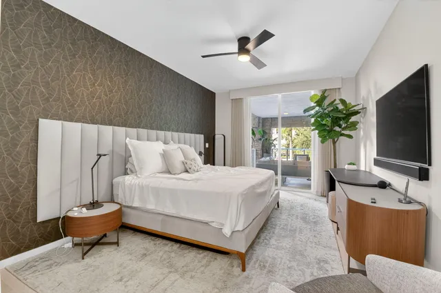 a spacious bedroom with a bed and a flat screen tv