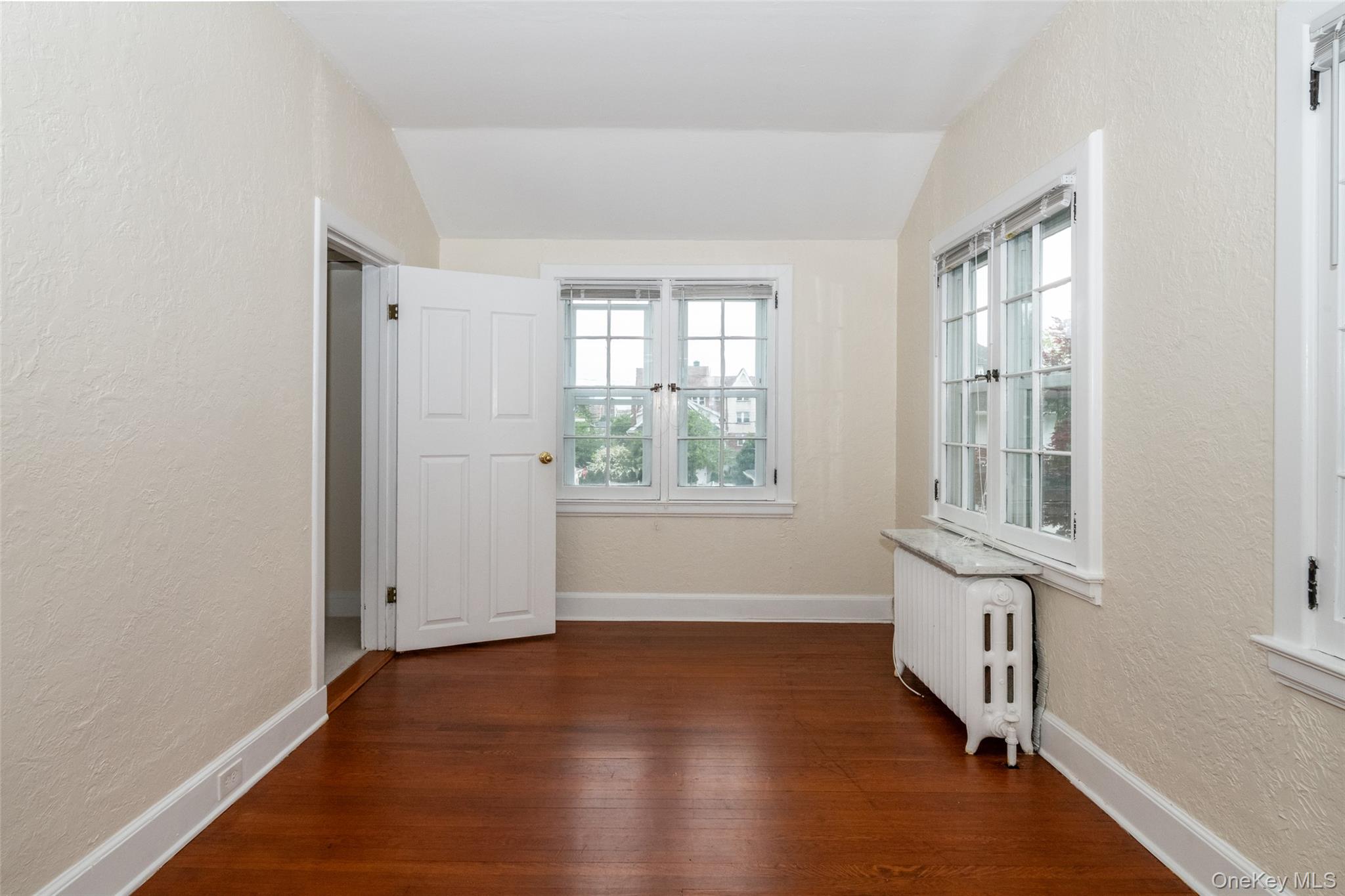 82 Clove Road New Rochelle, NY 10801 - Photo 19 of 39 an empty room with wooden floor and windows