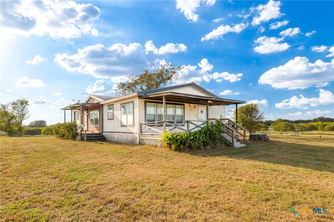 14858 Farm To Market Road 1322 Luling, TX 78648 - Photo 3 of 40 a front view of a house with garden