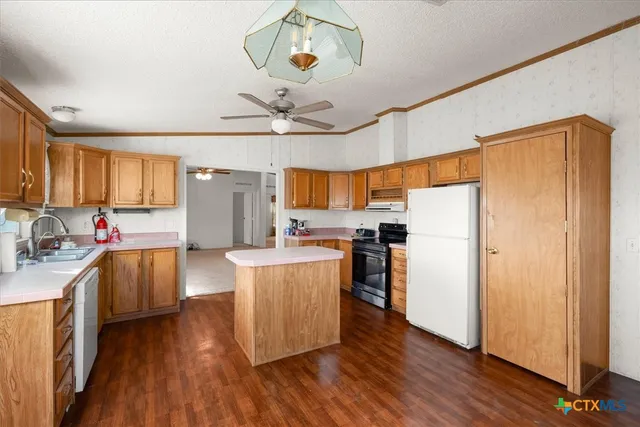 a kitchen with counter top space cabinets and wooden floor