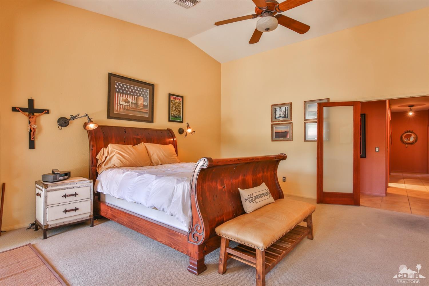 72187 Rancho Road Rancho Mirage, CA 92270 - Photo 17 of 25 a bedroom with a bed and a chandelier