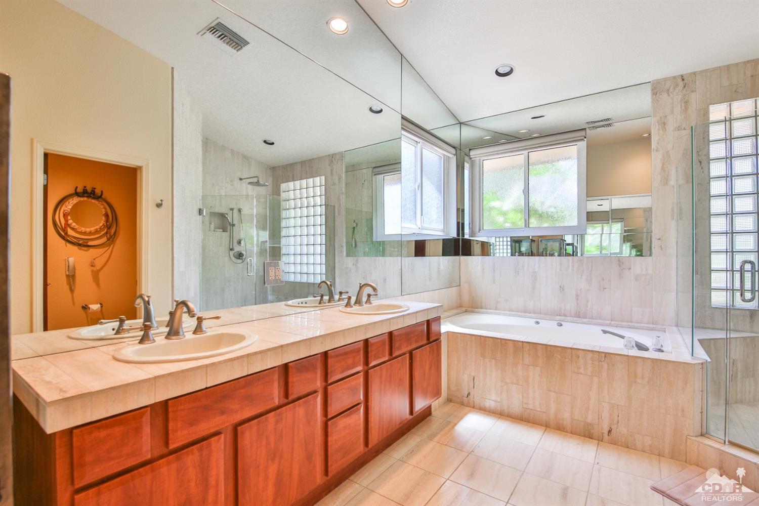 72187 Rancho Road Rancho Mirage, CA 92270 - Photo 18 of 25 a large bathroom with double vanity sinks a large mirror and a bathtub