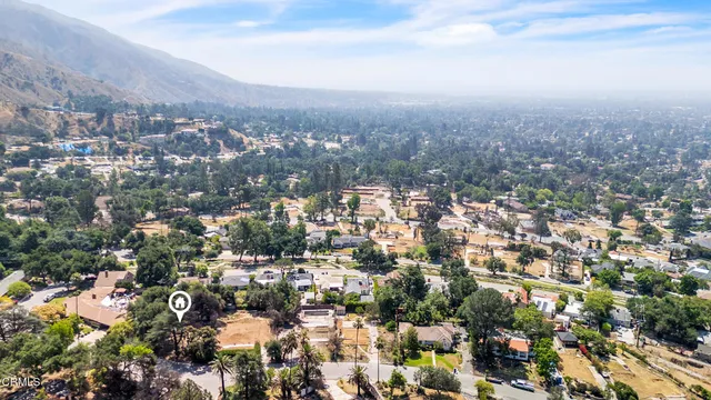 an aerial view of residential houses with outdoor space and trees all around