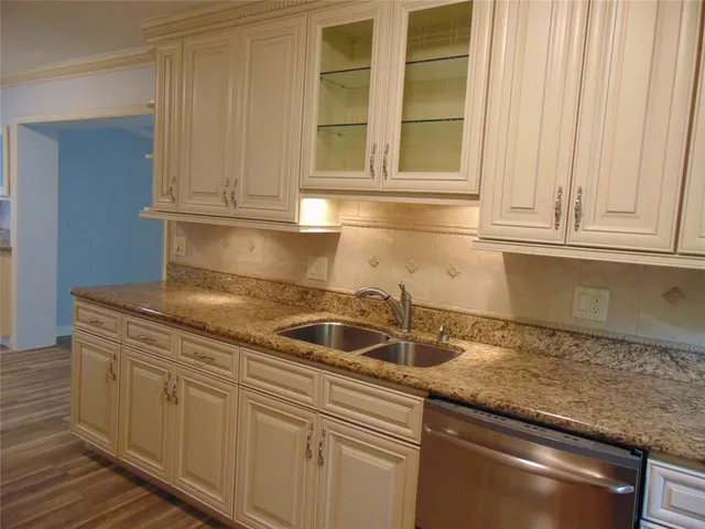 a kitchen with granite countertop a sink and cabinets