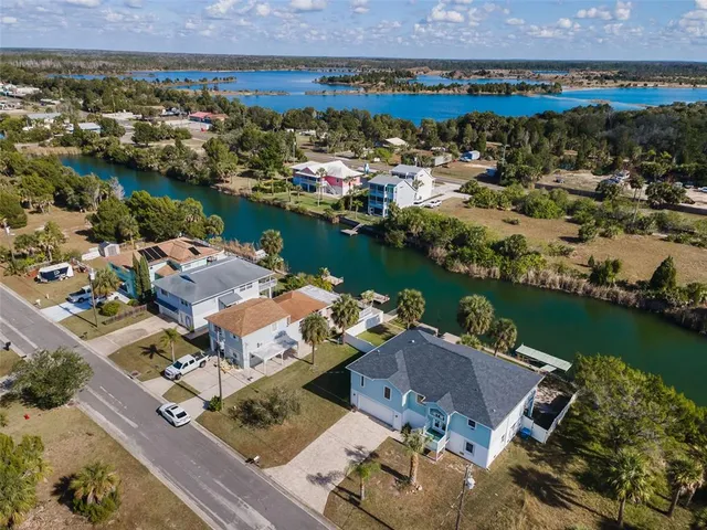 an aerial view of a house with a garden and lake view