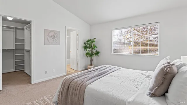 a bedroom with a bed and a potted plant