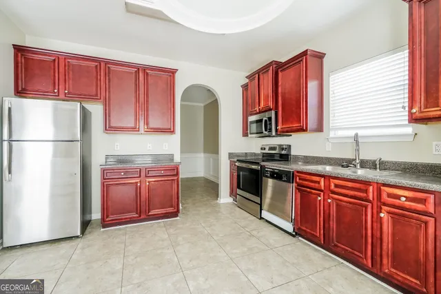 a kitchen with stainless steel appliances granite countertop a refrigerator and a sink