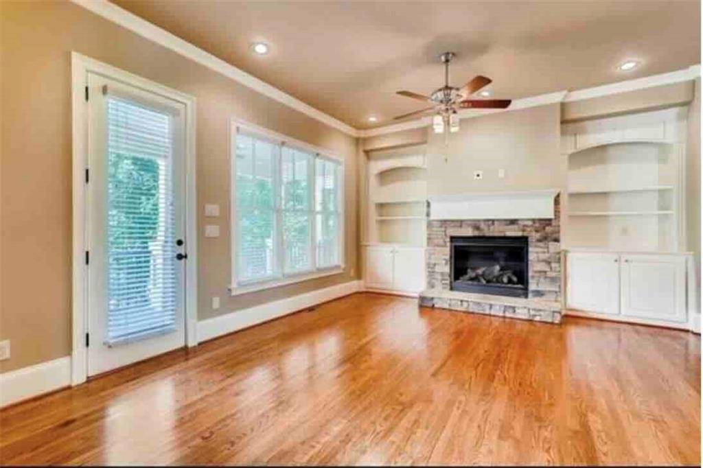 384 16th Street Northwest, Unit 1 Atlanta, GA 30363 - Photo 17 of 31 an empty room with wooden floor a fireplace a ceiling fan and windows