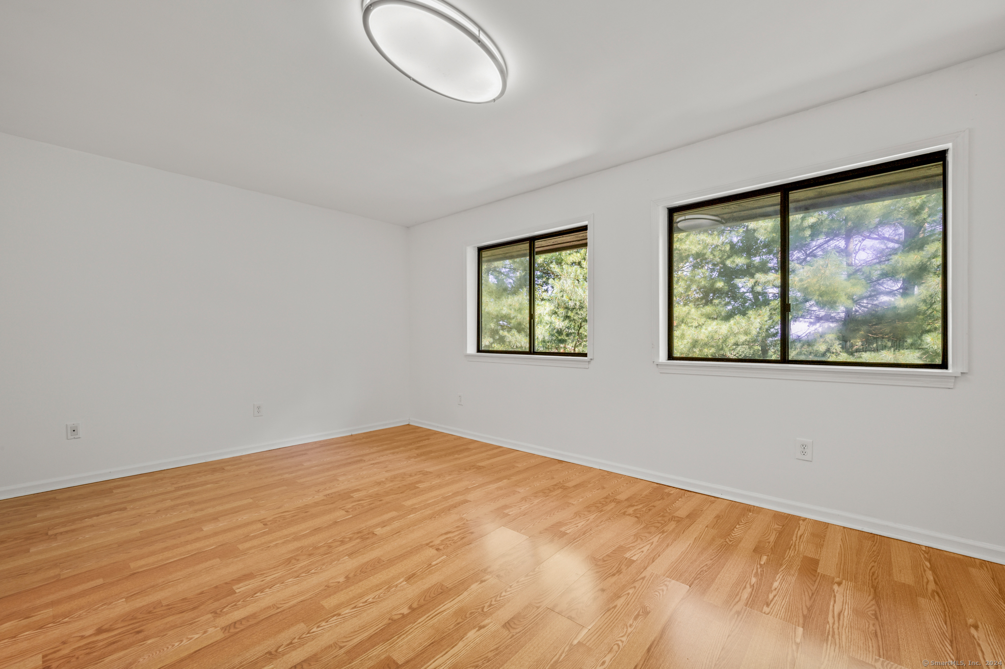 250 Conestoga Way, Unit 250 Glastonbury, CT 06033 - Photo 20 of 37 a view of empty room with wooden floor and fan