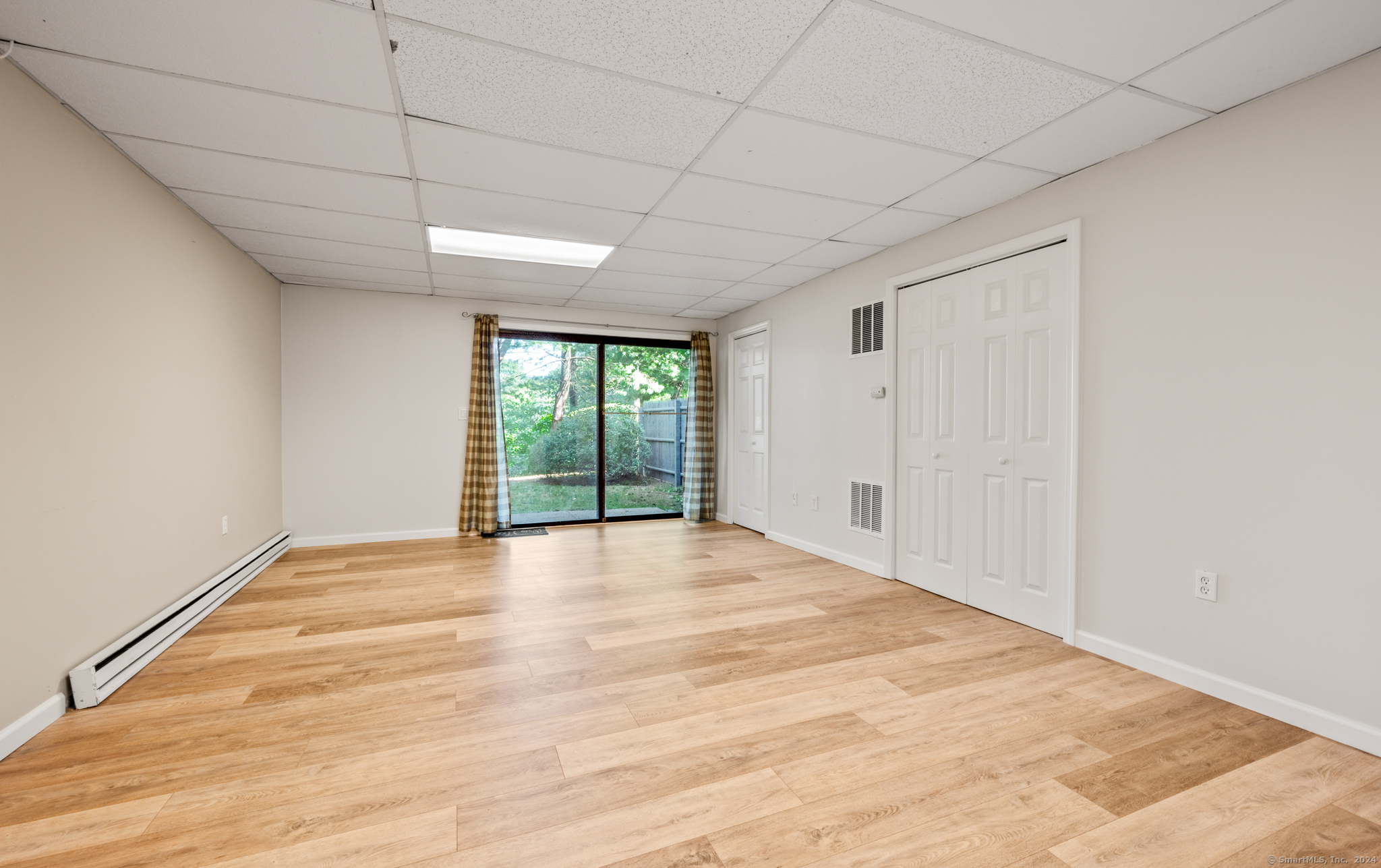 250 Conestoga Way, Unit 250 Glastonbury, CT 06033 - Photo 28 of 37 a view of an empty room with wooden floor and a window