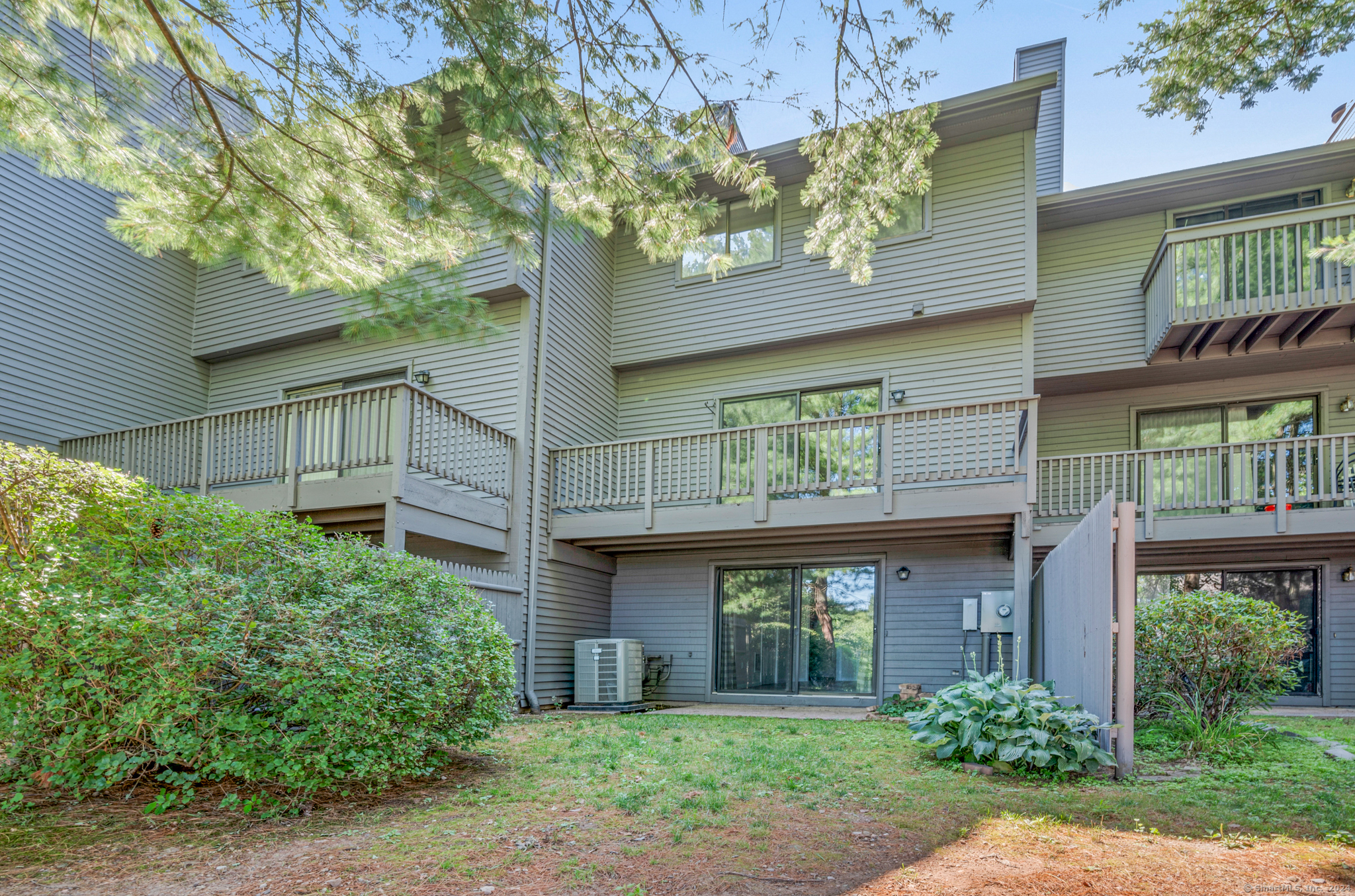 250 Conestoga Way, Unit 250 Glastonbury, CT 06033 - Photo 35 of 37 a view of a brick building next to a large tree