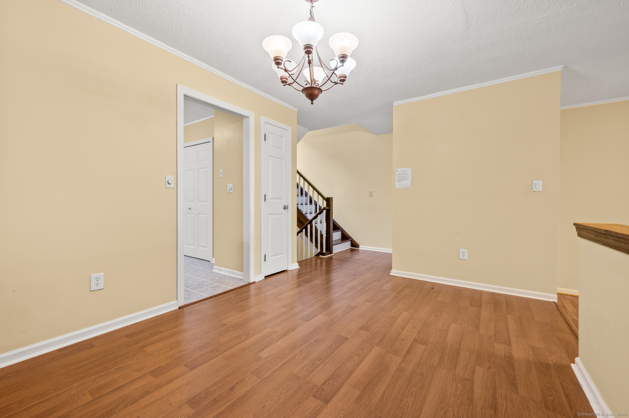 250 Conestoga Way, Unit 250 Glastonbury, CT 06033 - Photo 10 of 37 a view of a hallway with wooden floor and a chandelier