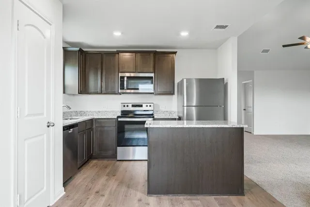 a large kitchen with a refrigerator and a stove top oven